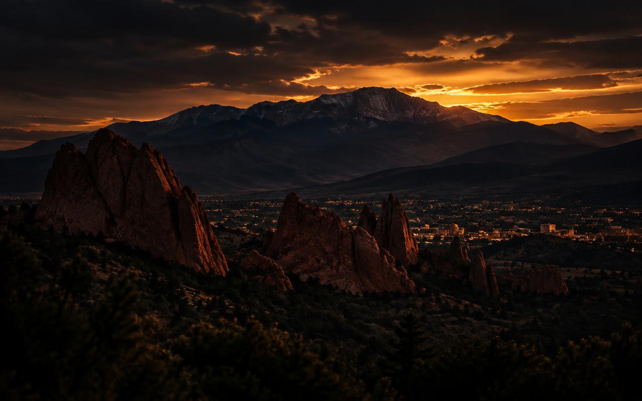 The Garden of the Gods formations and Pikes Peak above Colorado Springs at dusk